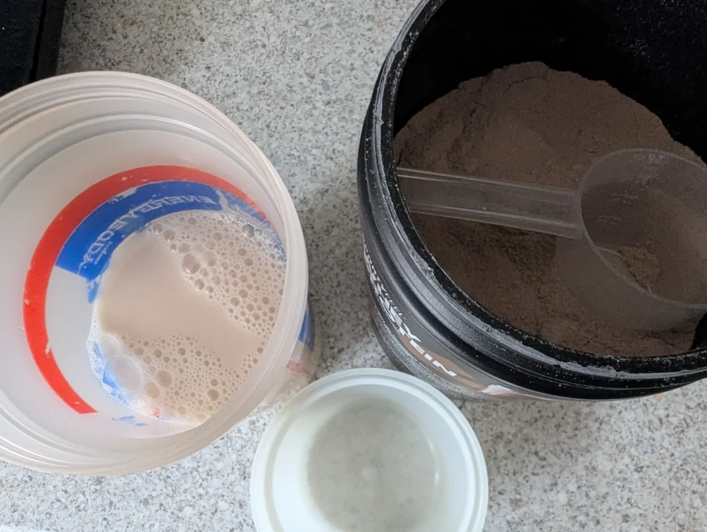 Shaker mit Eiweißpulver auf einer Arbeitsfläche